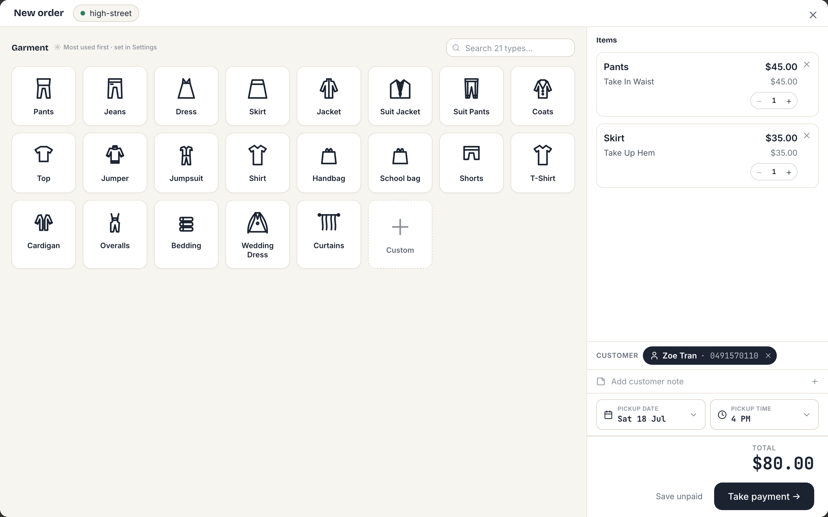 The order canvas: garment tile grid on the left, the live docket on the right with two items, the customer, pickup date and total.